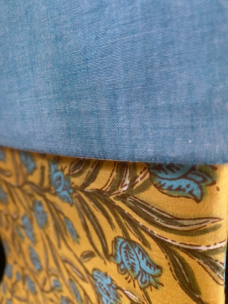 Close-up of blue fabric and gold floral-patterned fabric