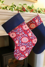 Floral-patterned Christmas stockings hanging on a fireplace mantle.