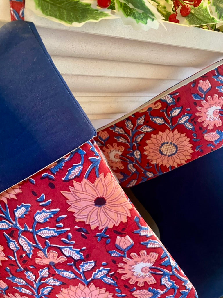 red and navy floral indian block print patterned christmas stockings hanging from fireplace