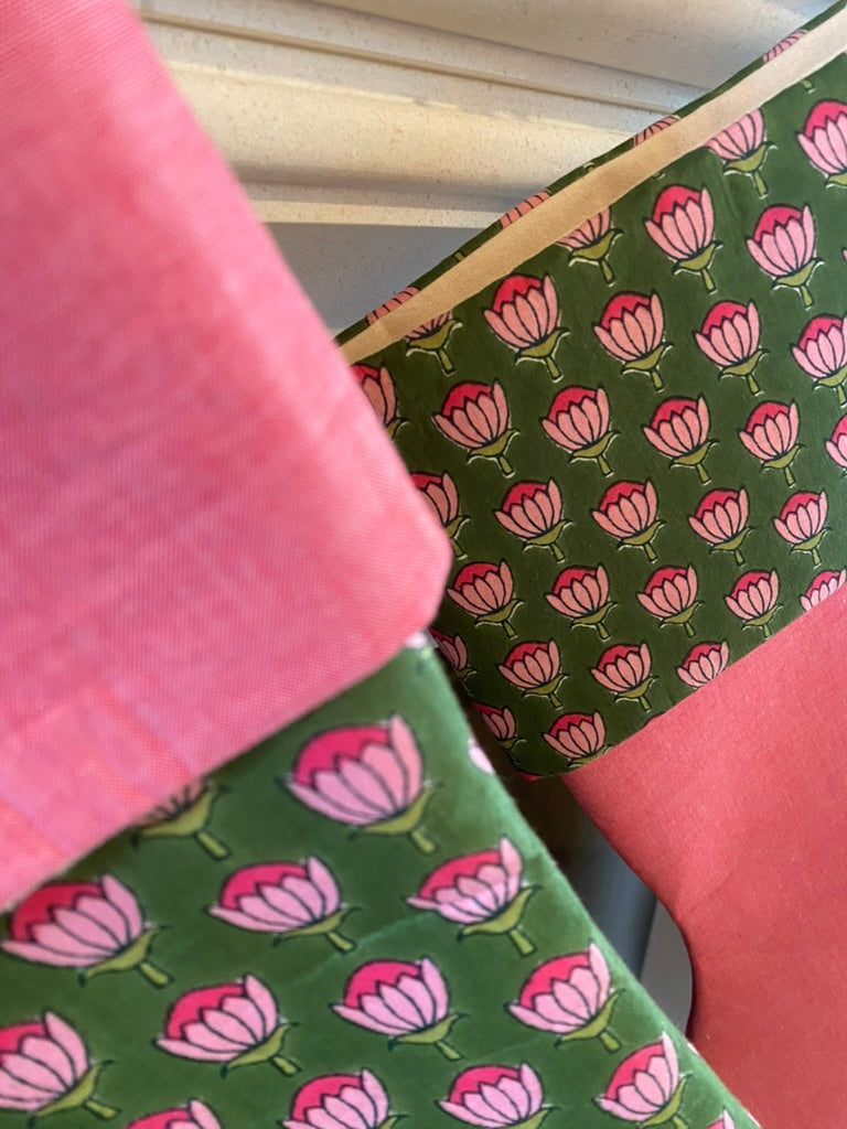 Close-up of green christmas stocking with pink floral pattern and pink trim.